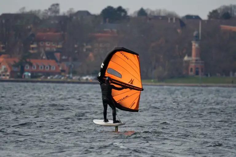 wing foiling - guy wing foiling with an orange wing