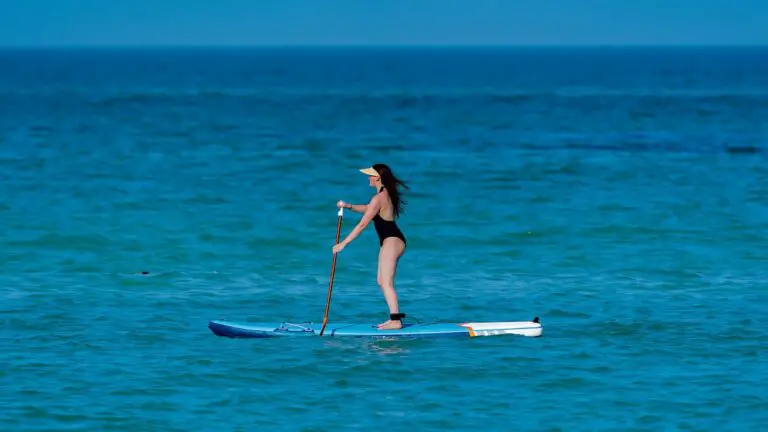 stand up paddle boarding. Lady on board in the ocean
