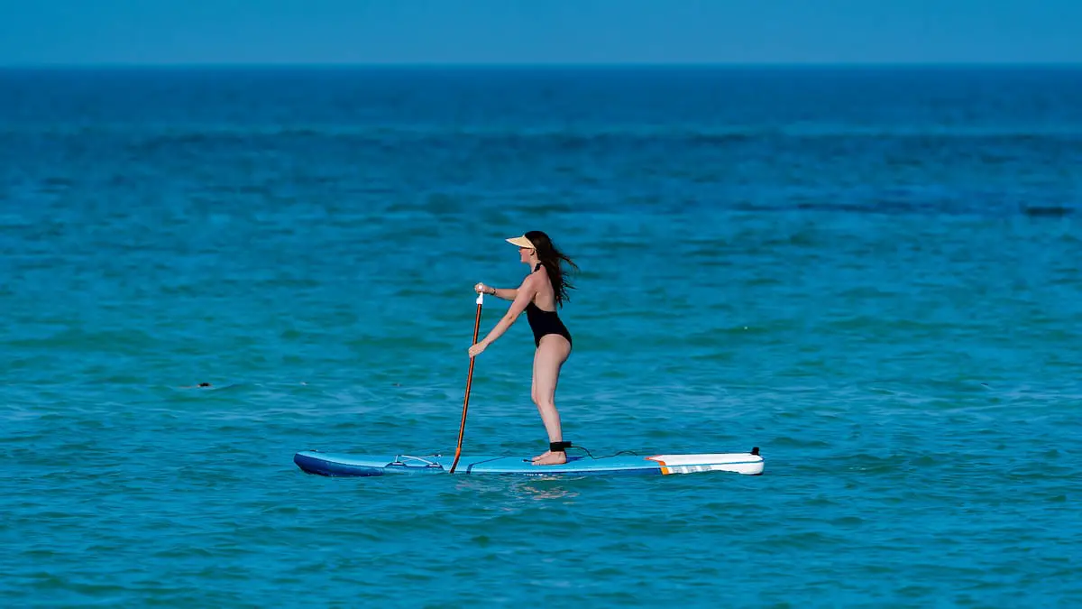 stand up paddle boarding. Lady on board in the ocean