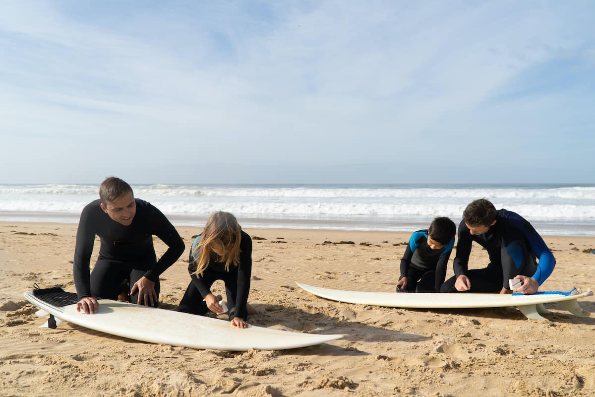 how to get into surfing - 2 instructors teaching 2 people how to get into surfing