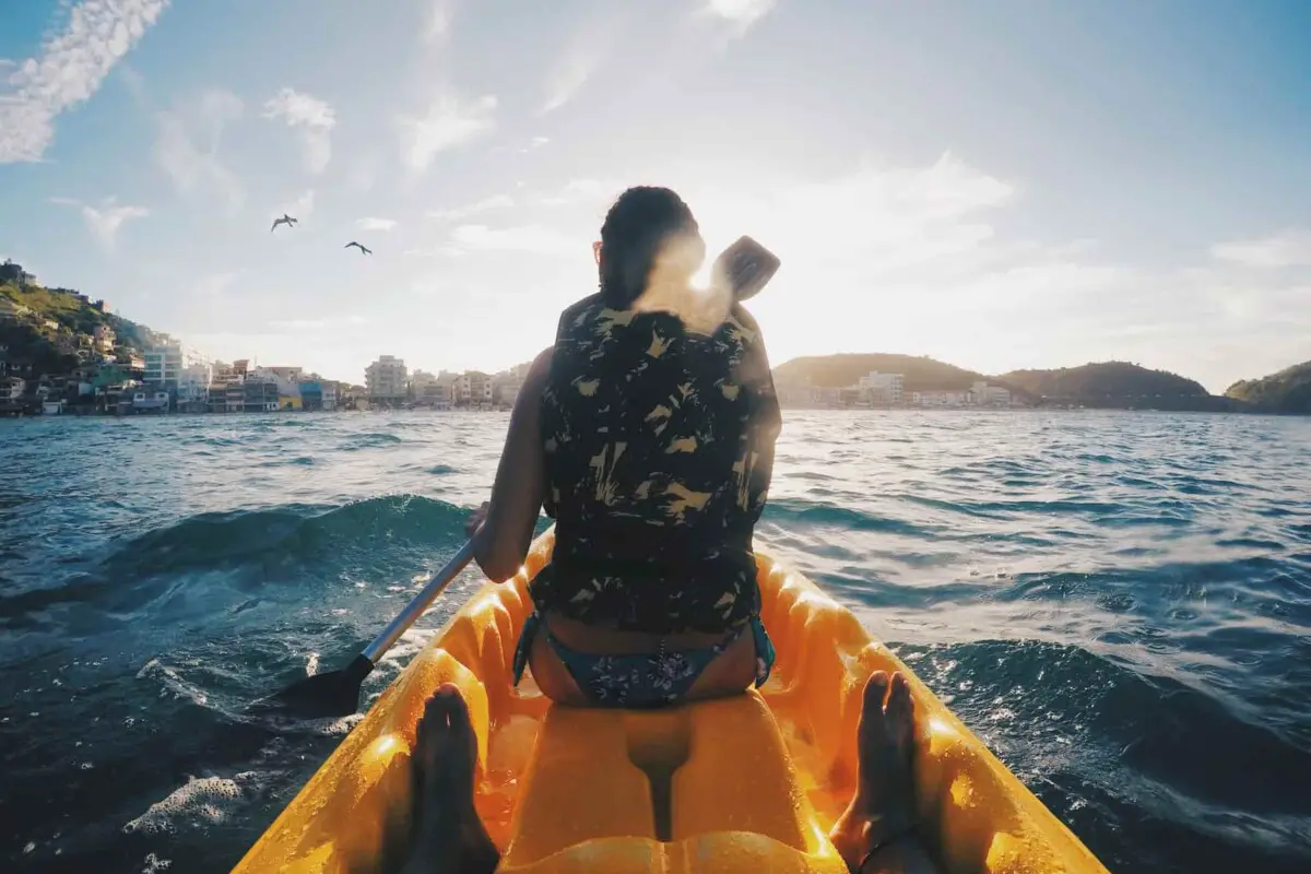 How to start kayaking. Person kayaking in a yellow kayak in the ocean